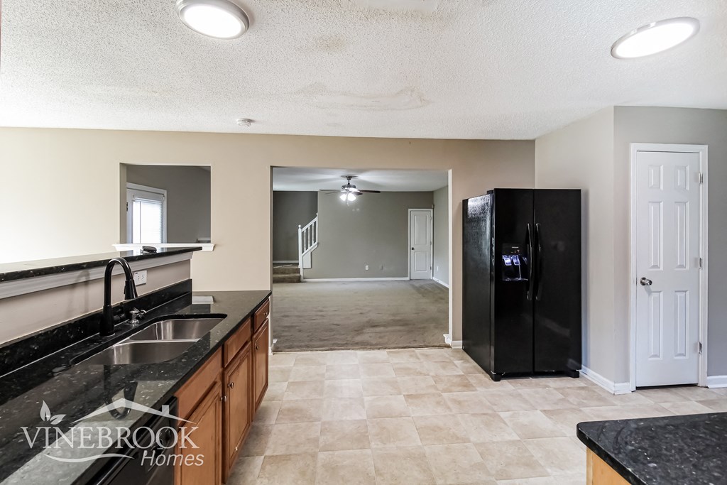 a kitchen with a sink and a refrigerator     and a living room