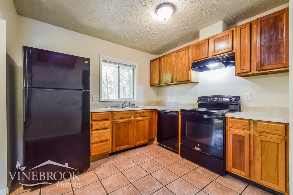 a kitchen with black appliances and wooden cabinets