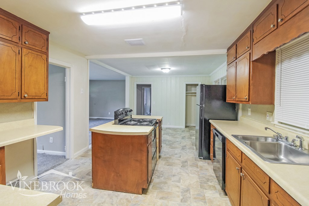 a kitchen with wood cabinets and stainless steel appliances