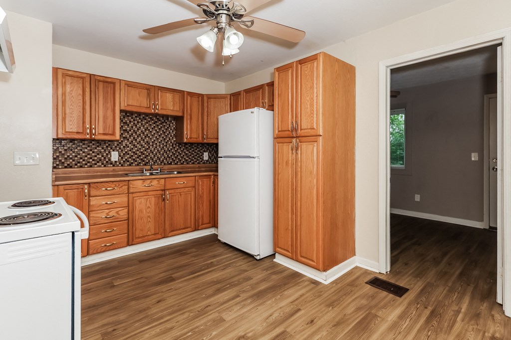 a kitchen with wooden cabinets and a white refrigerator