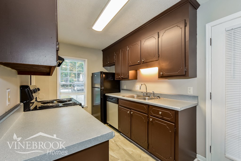 a kitchen with brown cabinets and a sink and a refrigerator