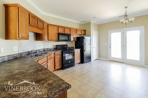 A kitchen with wooden cabinets and a granite countertop.