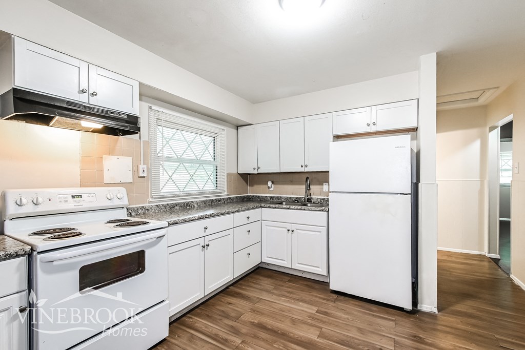 a white kitchen with white appliances and white cabinets