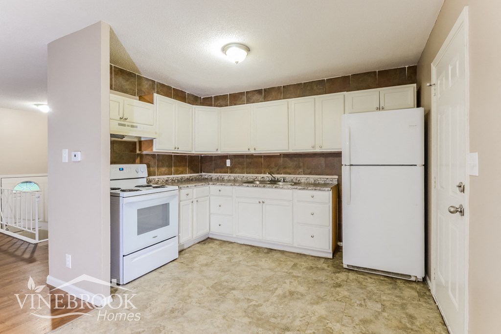 a kitchen with white appliances and white cabinets and a white refrigerator