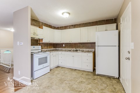 a kitchen with white appliances and white cabinets and a white refrigerator