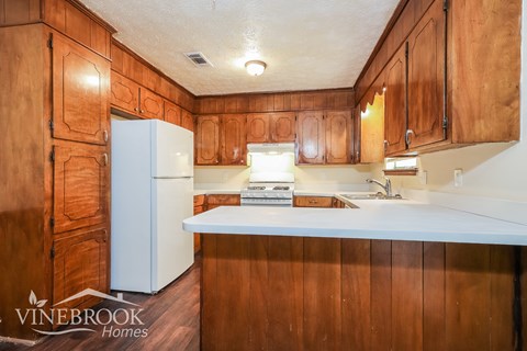 a kitchen with wooden cabinets and a white counter top