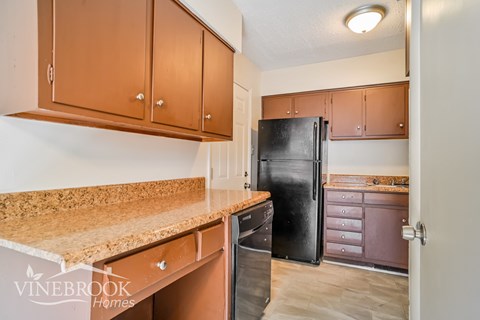 a kitchen with a counter top and a black refrigerator