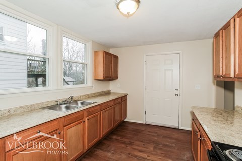 A kitchen with wooden cabinets and a sink.