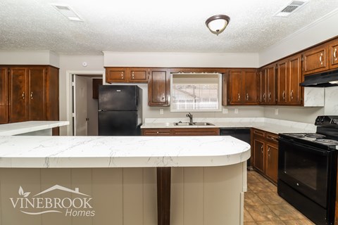 A kitchen with a Vinebrook Homes logo on the island.