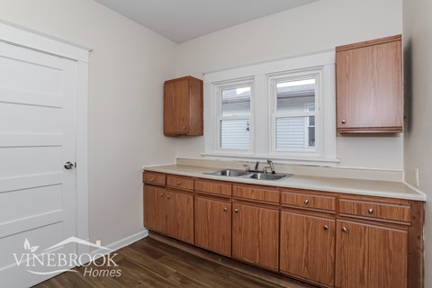 A kitchen with wooden cabinets and a white door.