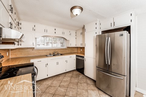 A kitchen with a refrigerator on the right and a stove on the left.