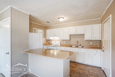 A kitchen with white cabinets and a countertop.