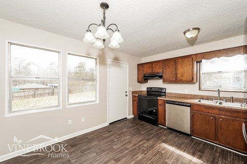 A kitchen with wood cabinets and a dishwasher.