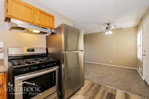 A kitchen with a stove top oven and a refrigerator.