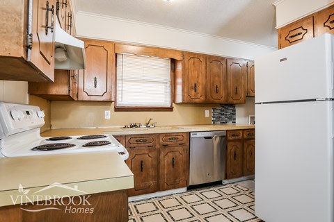 A kitchen with wooden cabinets and a white refrigerator.