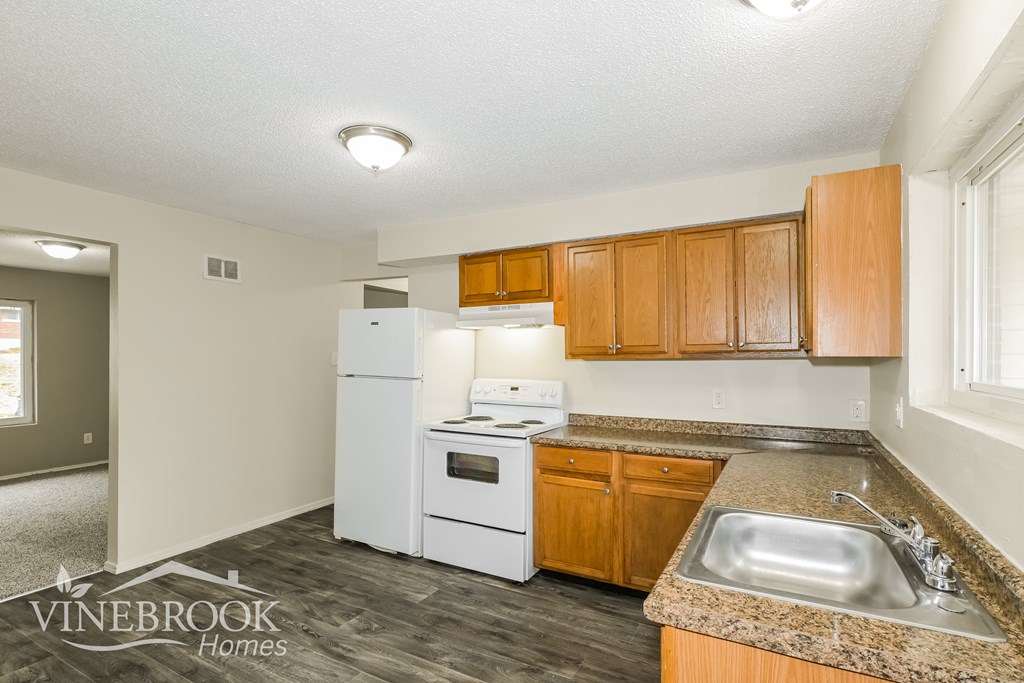 A kitchen with a white refrigerator, stove, and oven.