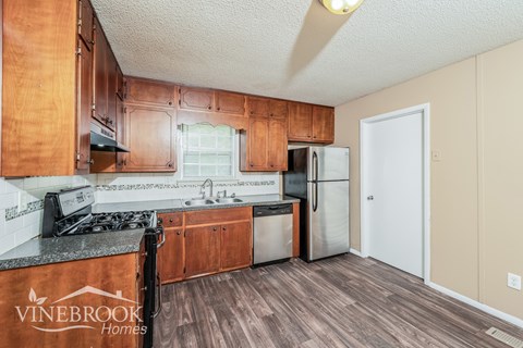 A kitchen with wooden cabinets and a black stove top.