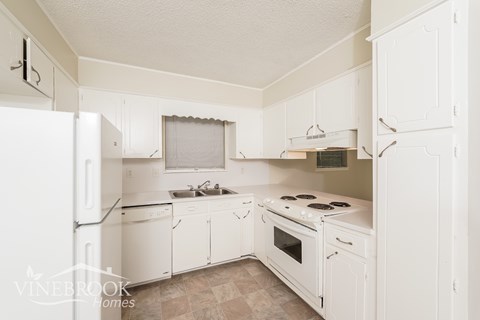 A white kitchen with a Vinebrook Homes logo.