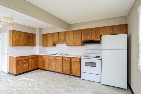 A kitchen with wooden cabinets and a white refrigerator.