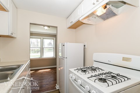 A kitchen with a white stove and a window.