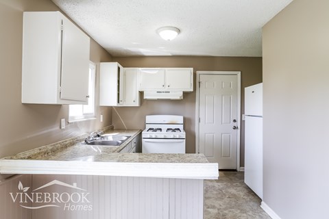 A kitchen with white cabinets and appliances is shown.