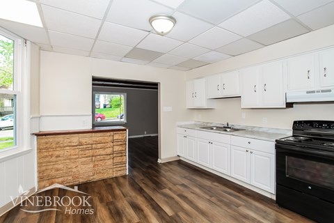 A kitchen with white cabinets and a black stove top oven.