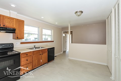 A kitchen with wooden cabinets and black appliances.