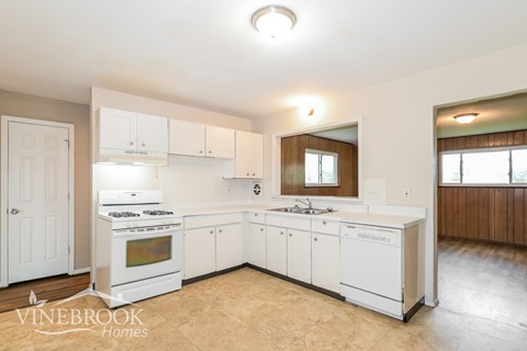 A kitchen with white cabinets and appliances is shown.