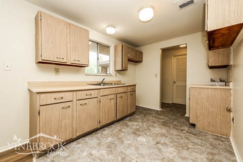 A kitchen with wooden cabinets and a countertop.