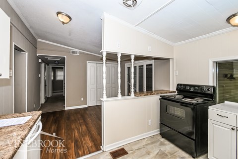 A kitchen with a black stove top oven and white cabinets.