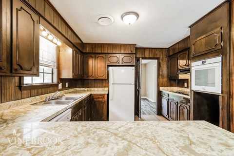 A kitchen with wooden cabinets and a white refrigerator.
