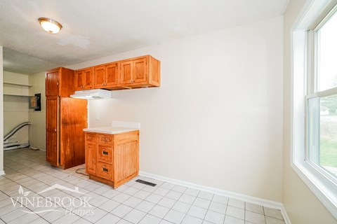 A kitchen area with wooden cabinets and a white countertop.