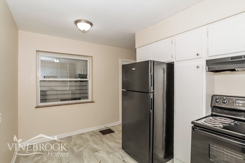 A kitchen with a black fridge and stove.