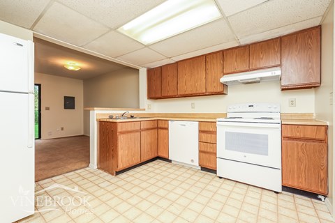 A kitchen with wooden cabinets and white appliances.