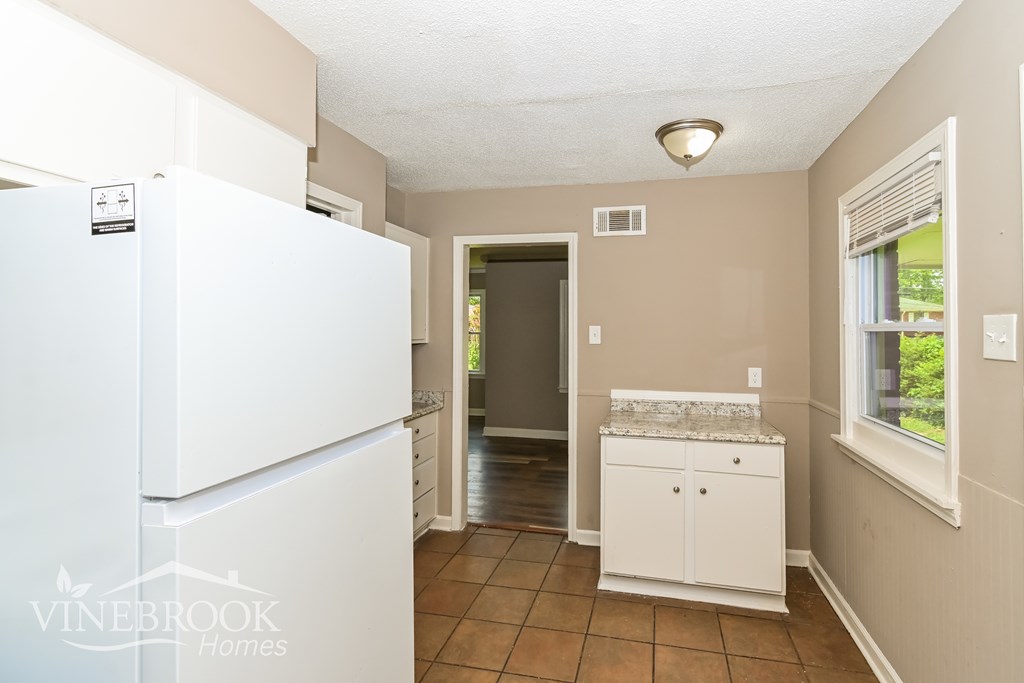 A kitchen with a white fridge and a white cabinet.