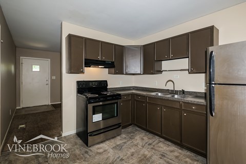 A kitchen with brown cabinets and a black stove top oven.