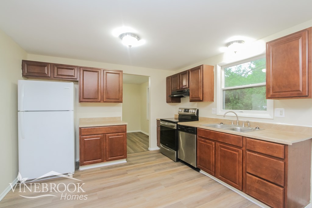 A kitchen with wooden cabinets and a white refrigerator.