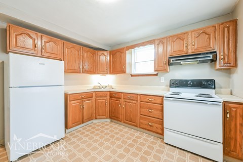 A kitchen with wooden cabinets and a white refrigerator.