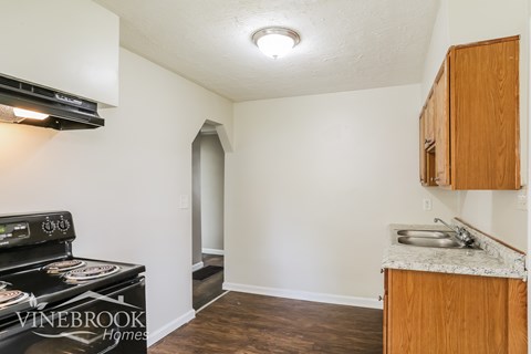 A kitchen with a stove top oven and cabinets.