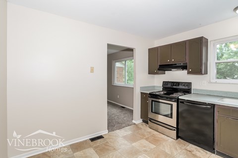 A kitchen with a black oven and a window.