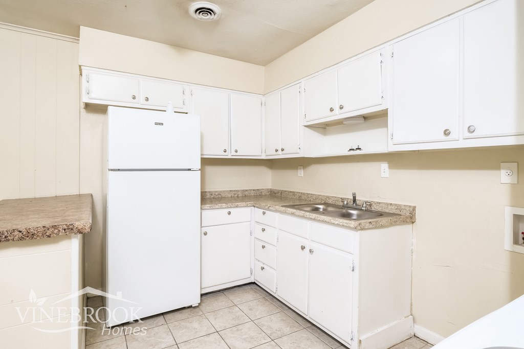 A white kitchen with a Vinebrook Homes logo.