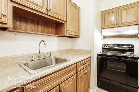 A kitchen with wooden cabinets and a stove top oven.