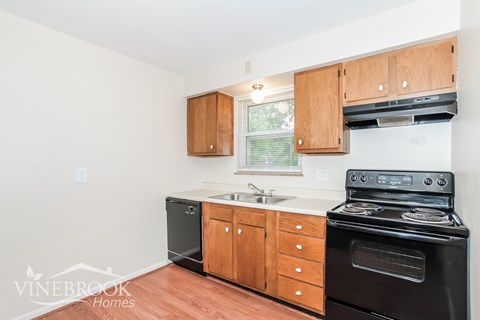 A kitchen with wooden cabinets and black appliances.