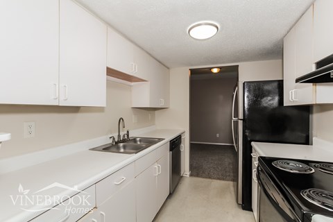 A kitchen with white cabinets and appliances.