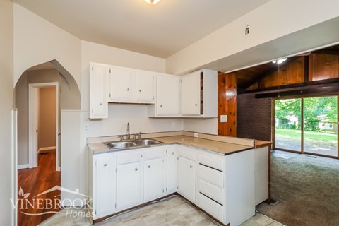 A kitchen with white cabinets and a sink.