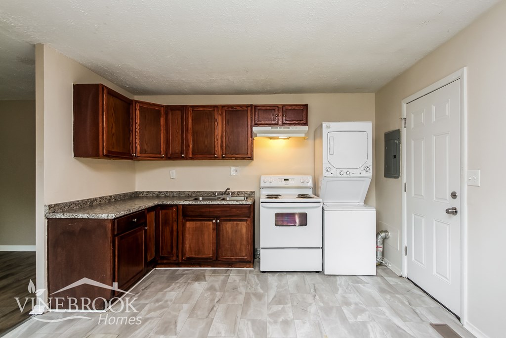 A kitchen with wooden cabinets and a white fridge.