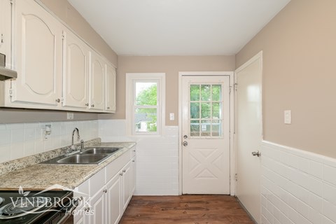 A kitchen with white cabinets and a sink.