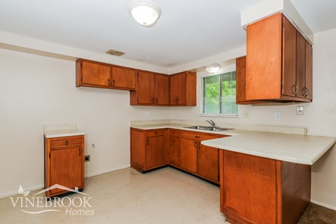 A kitchen with wooden cabinets and a sink.