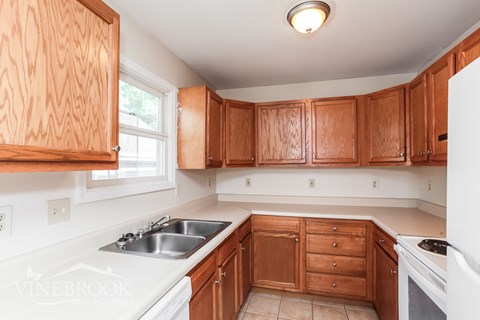 A kitchen with wooden cabinets and white appliances.