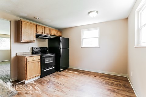 A kitchen with wooden cabinets and black appliances.